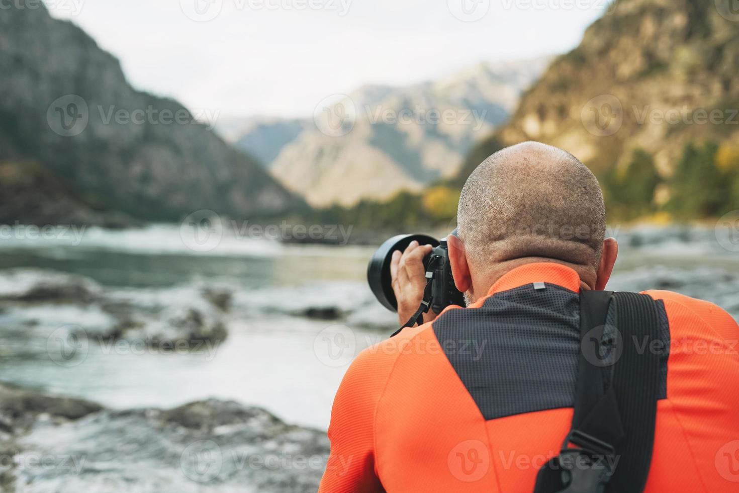 Landscape photographer at work. Photographer shoots beautiful view of Katun river Altai mountains photo