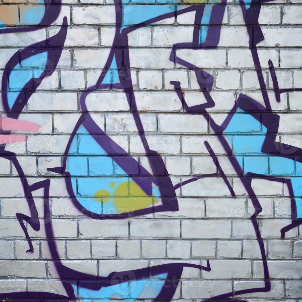 Fragment of graffiti drawings. The old wall decorated with paint stains in the style of street art culture. Colored background texture photo