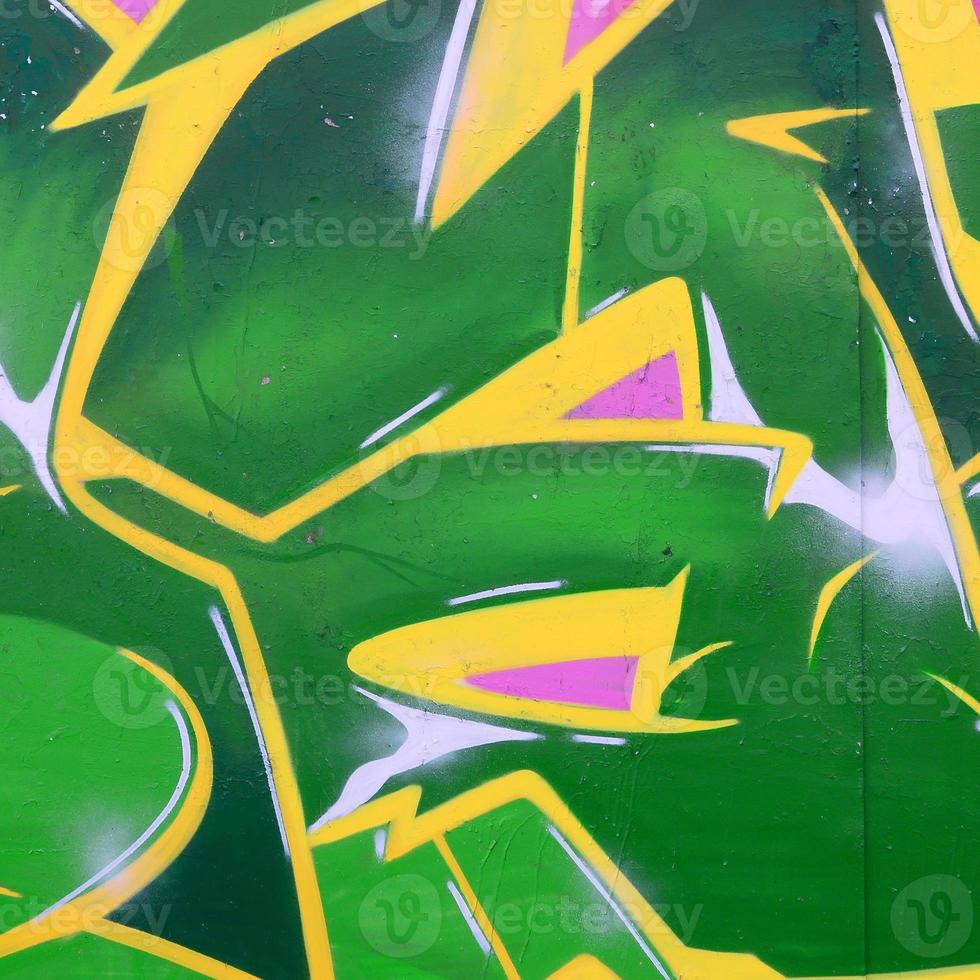 Fragment of graffiti drawings. The old wall decorated with paint stains in the style of street art culture. Colored background texture photo