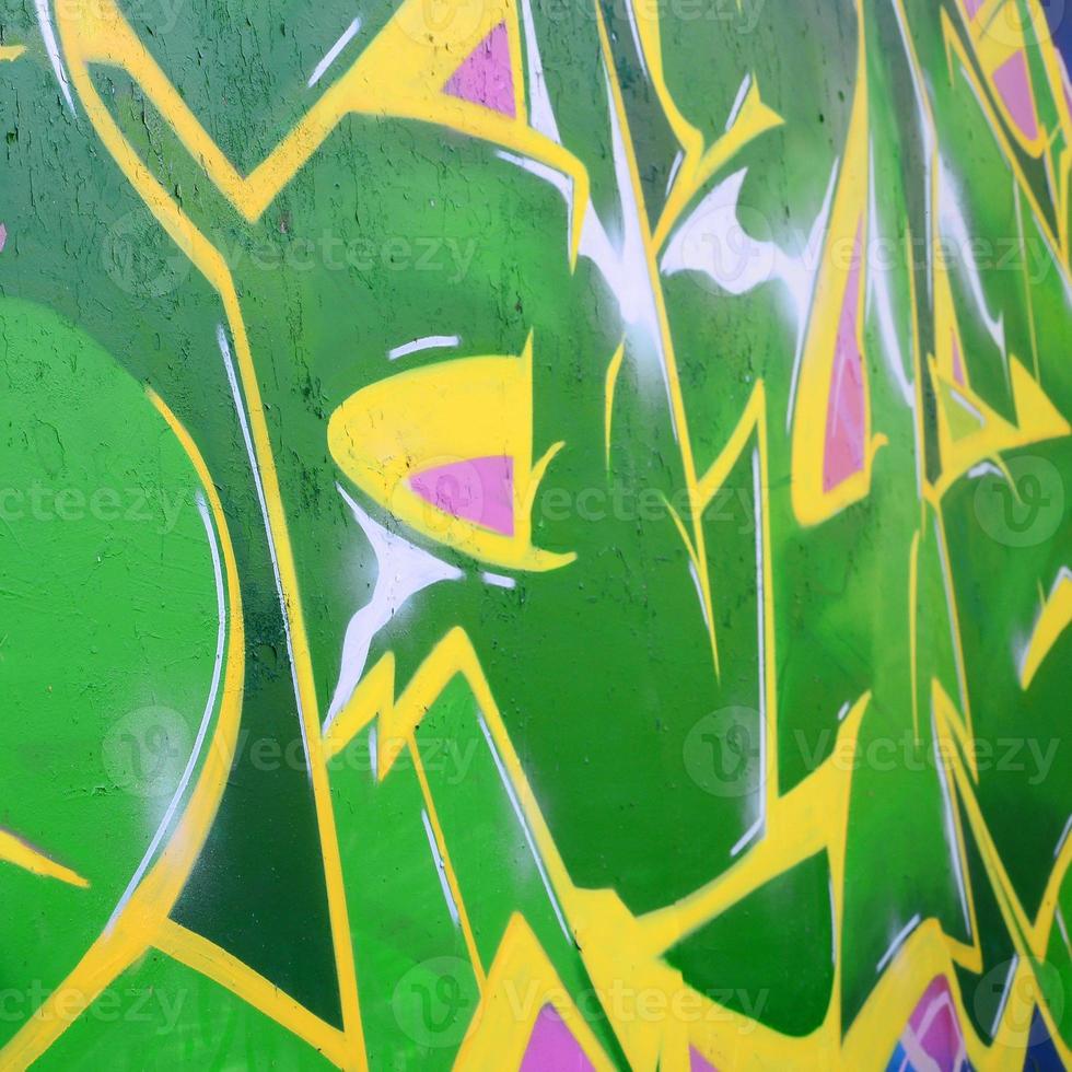 Fragment of graffiti drawings. The old wall decorated with paint stains in the style of street art culture. Colored background texture photo