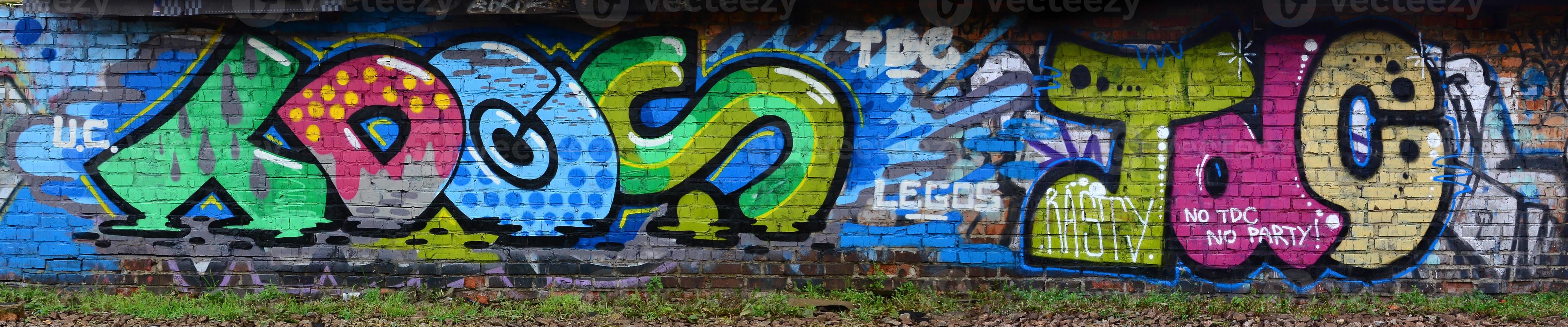 Full and acomplished graffiti artwork. The old wall decorated with paint stains in the style of street art culture. Colored background texture photo