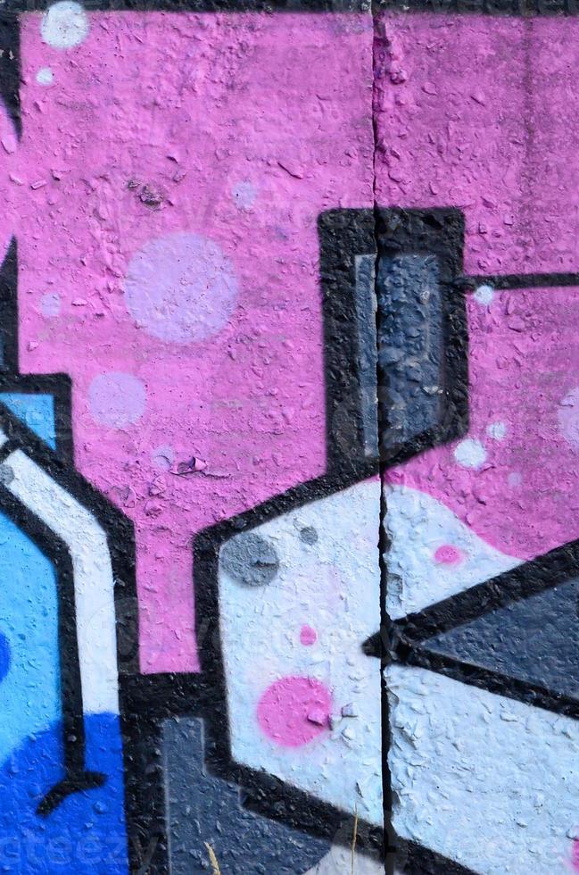 Fragment of graffiti drawings. The old wall decorated with paint stains in the style of street art culture. Colored background texture photo