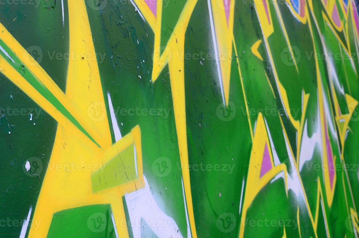 Fragment of graffiti drawings. The old wall decorated with paint stains in the style of street art culture. Colored background texture photo