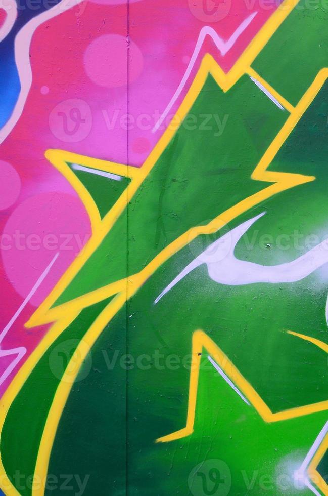 Fragment of graffiti drawings. The old wall decorated with paint stains in the style of street art culture. Colored background texture photo