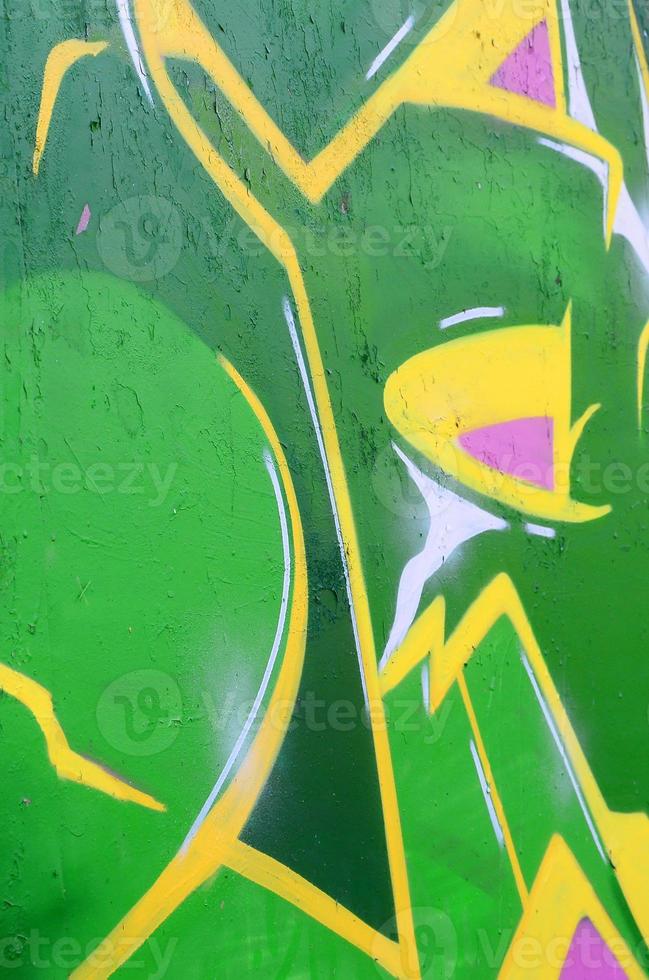 Fragment of graffiti drawings. The old wall decorated with paint stains in the style of street art culture. Colored background texture photo