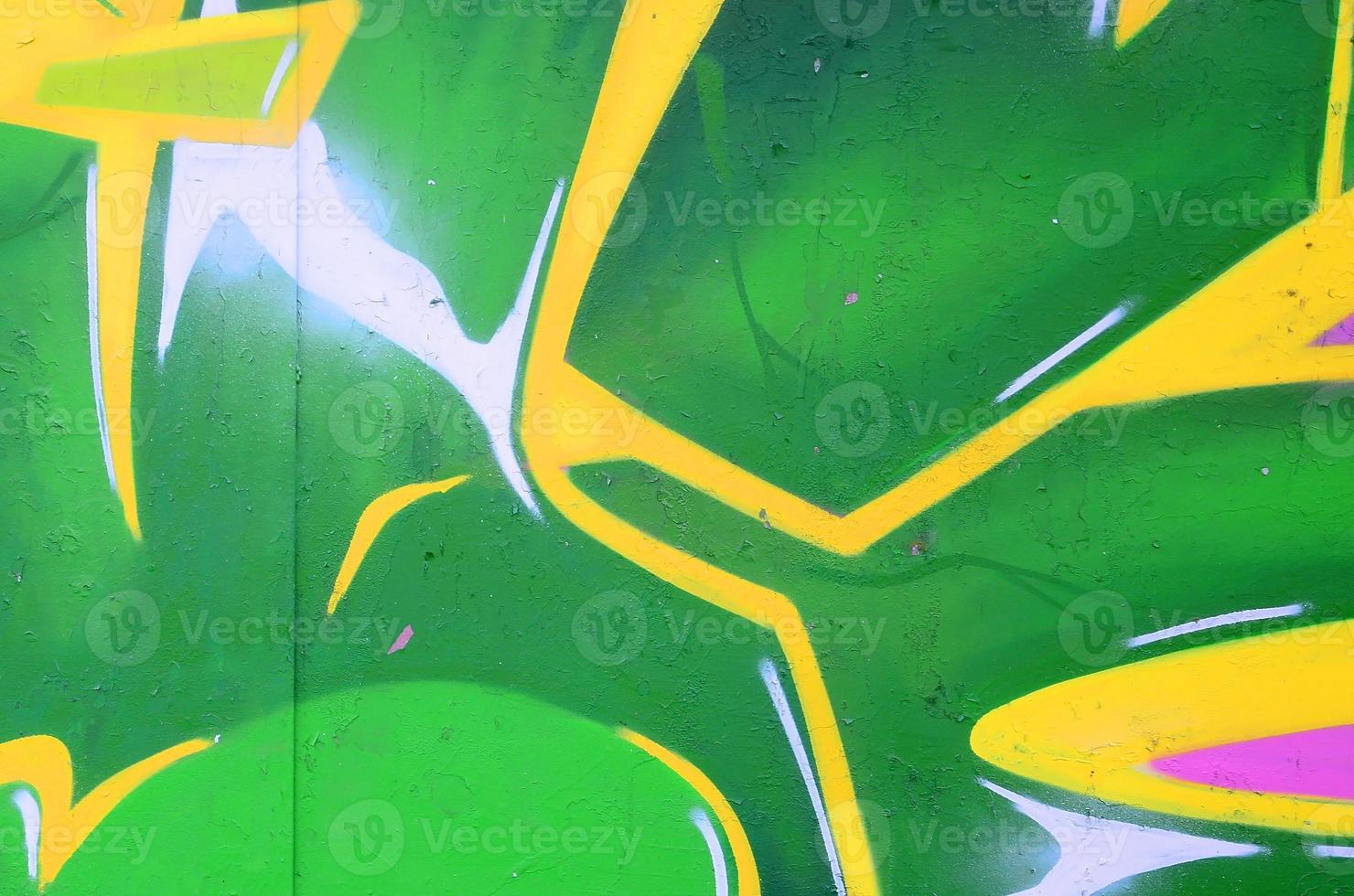 Fragment of graffiti drawings. The old wall decorated with paint stains in the style of street art culture. Colored background texture photo