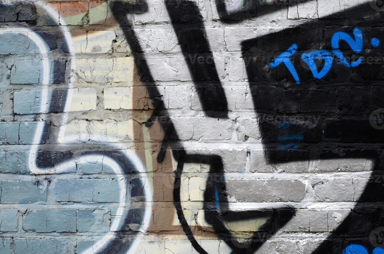 Fragment of graffiti drawings. The old wall decorated with paint stains in the style of street art culture. Colored background texture photo