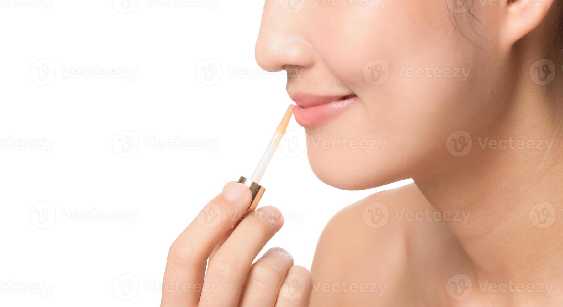Beautiful portrait young asian woman looking mirror applying makeup lipstick at room. clipping path photo