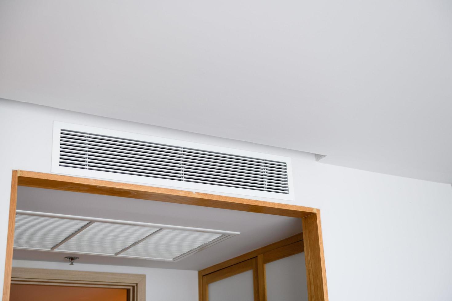 Ceiling mounted cassette type air conditioner and modern lamp light on white ceiling. duct air conditioner for home or office photo