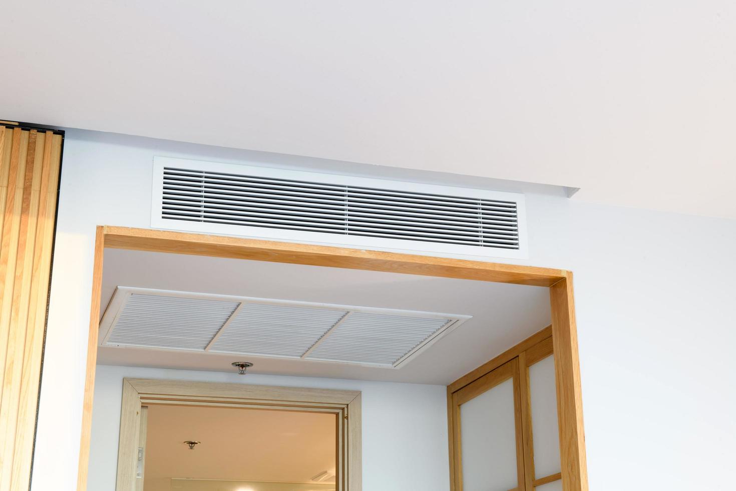 Ceiling mounted cassette type air conditioner and modern lamp light on white ceiling. duct air conditioner for home or office photo