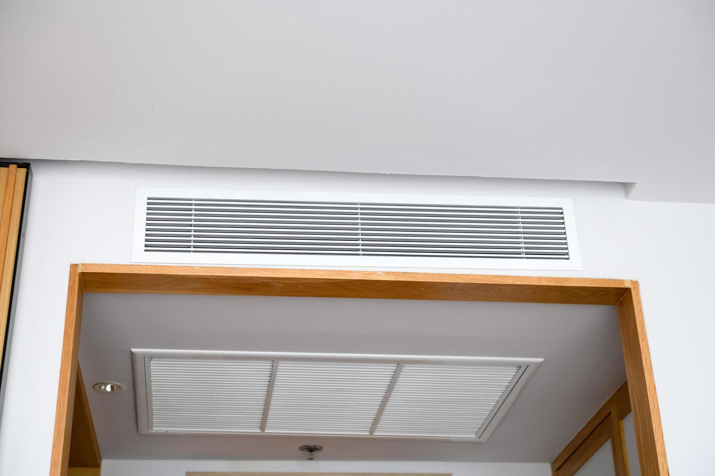 Ceiling mounted cassette type air conditioner and modern lamp light on white ceiling. duct air conditioner for home or office photo