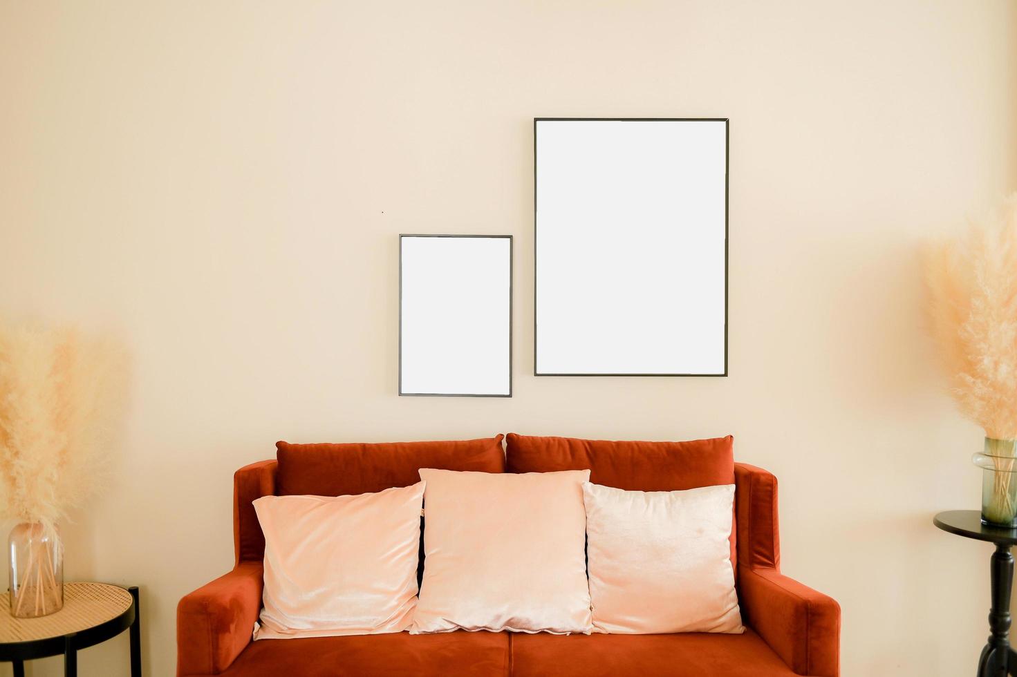 Warm and cozy interior of living room space with brown sofa, mock up poster frame, decoration, plant and coffee table. Cozy home decor. photo