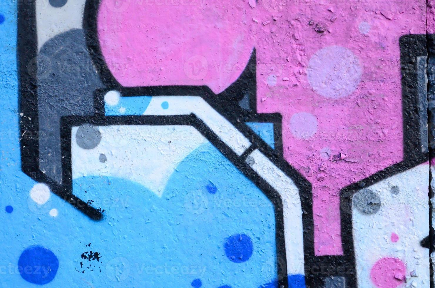 Fragment of graffiti drawings. The old wall decorated with paint stains in the style of street art culture. Colored background texture photo
