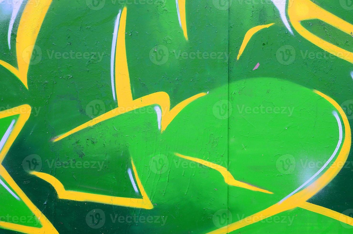 Fragment of graffiti drawings. The old wall decorated with paint stains in the style of street art culture. Colored background texture photo