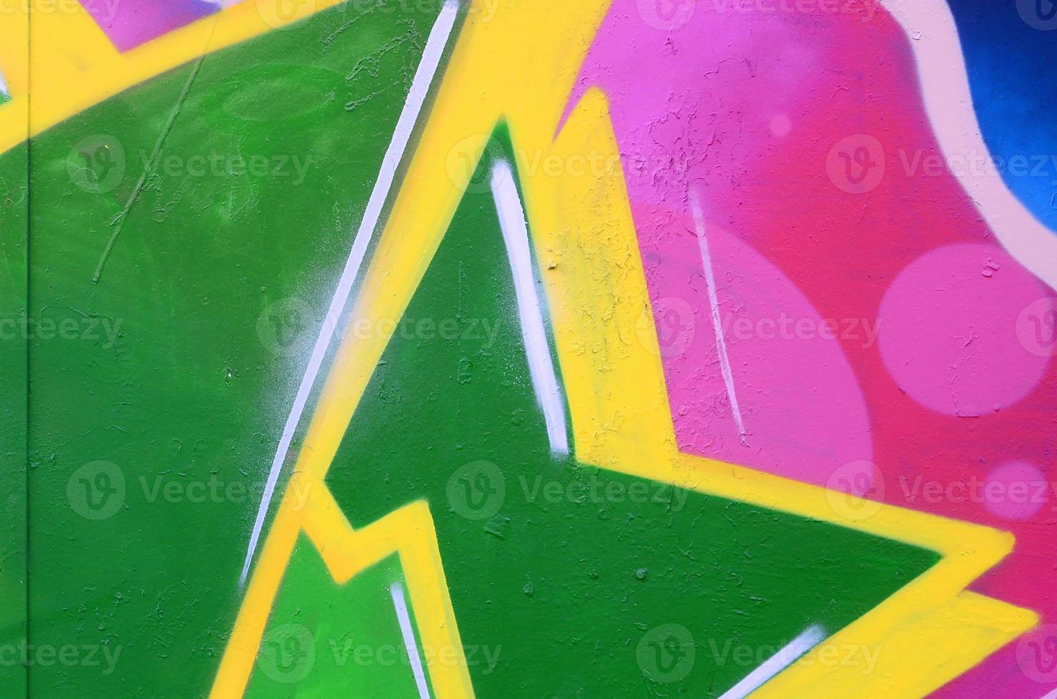 Fragment of graffiti drawings. The old wall decorated with paint stains in the style of street art culture. Colored background texture photo