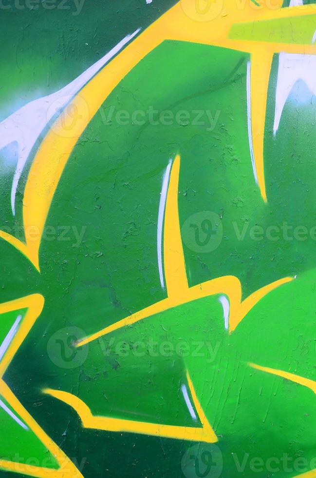 Fragment of graffiti drawings. The old wall decorated with paint stains in the style of street art culture. Colored background texture photo