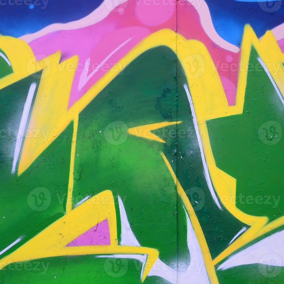 Fragment of graffiti drawings. The old wall decorated with paint stains in the style of street art culture. Colored background texture photo