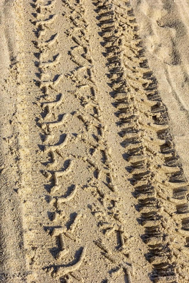 Traces of different car tires on the sand of the sea beach. Close up photo