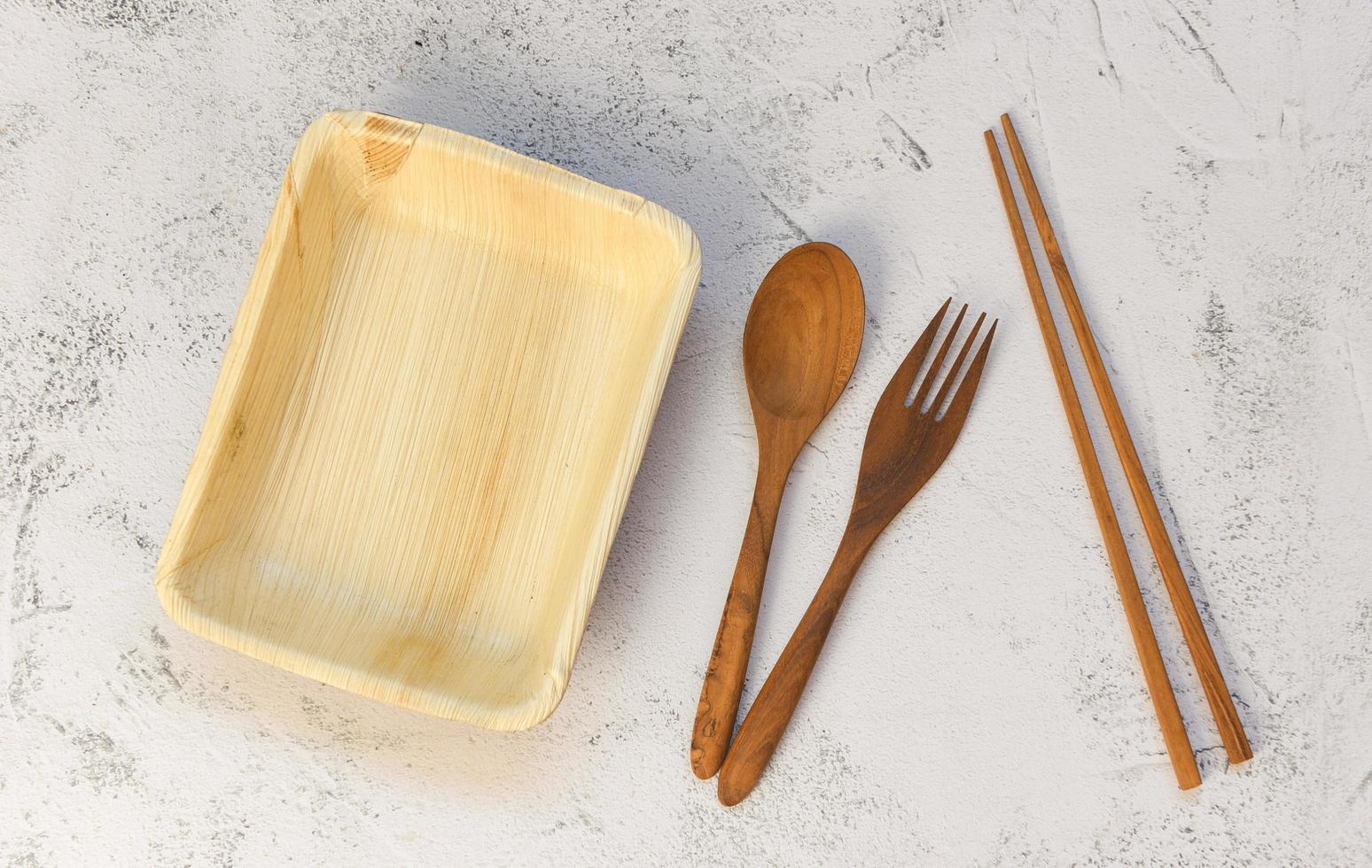 Eco friendly disposable tableware from palm leaf or betel nut , zero waste environment concept Natural eco-friendly food packaging disposable utensils with dish plate and wooden fork spoon photo