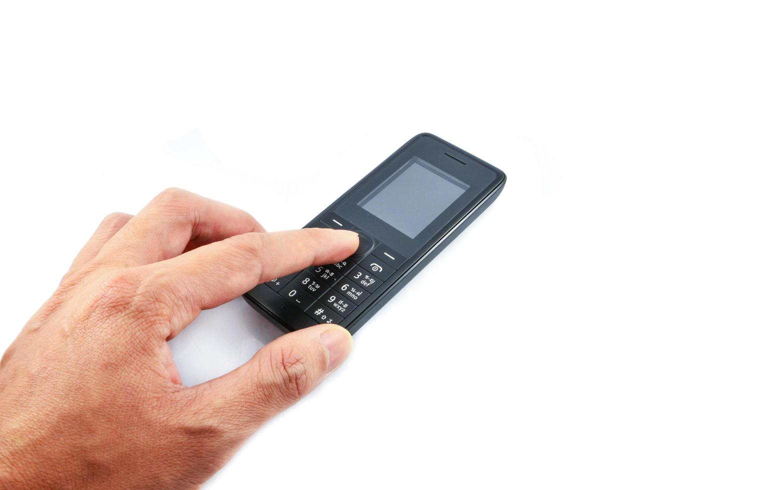 Mano presionando sobre el teléfono modelo antiguo teléfono móvil aislado sobre fondo blanco. foto