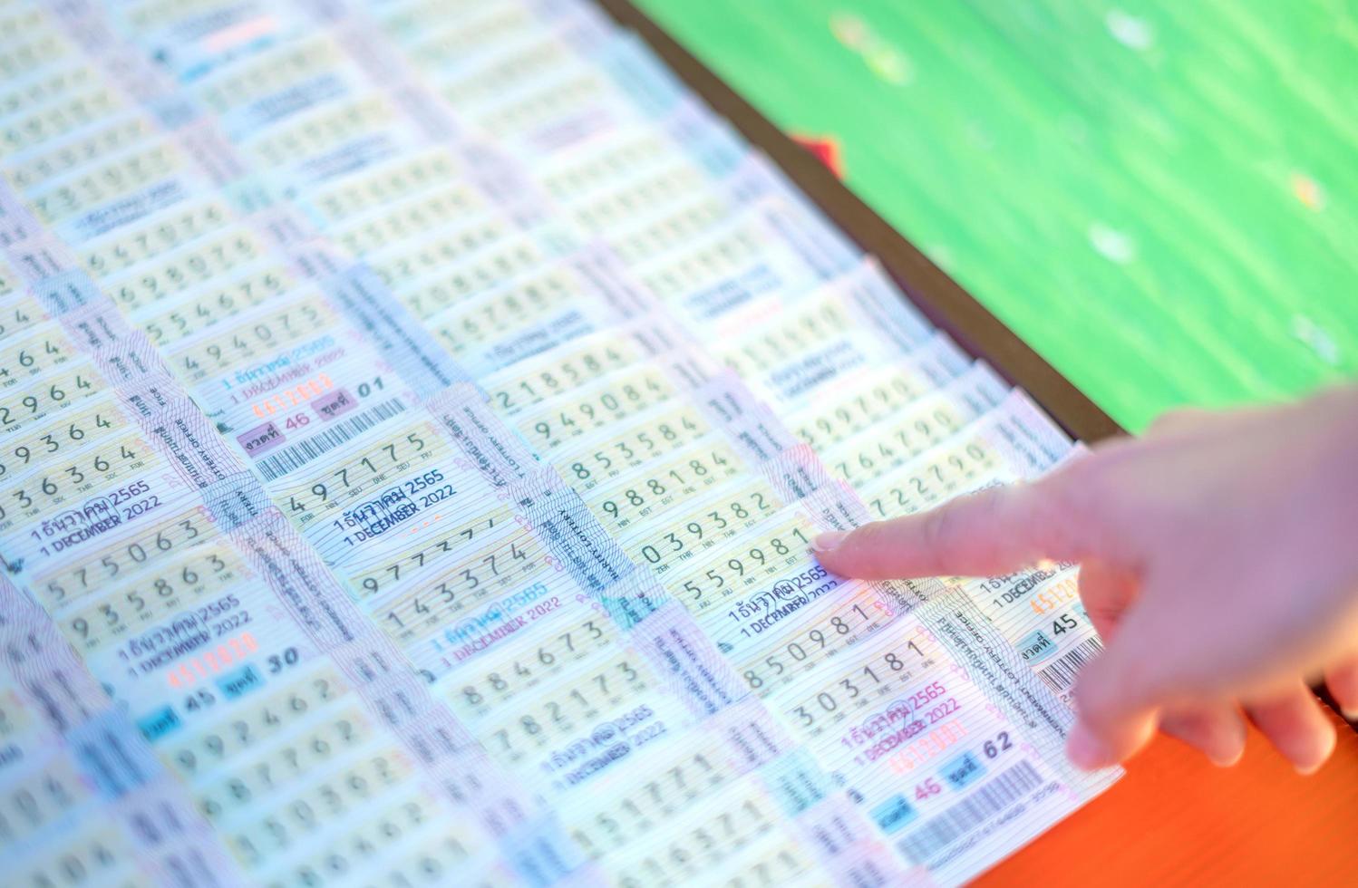 The female hand choosing Thailand government lottery from the street vendor. photo