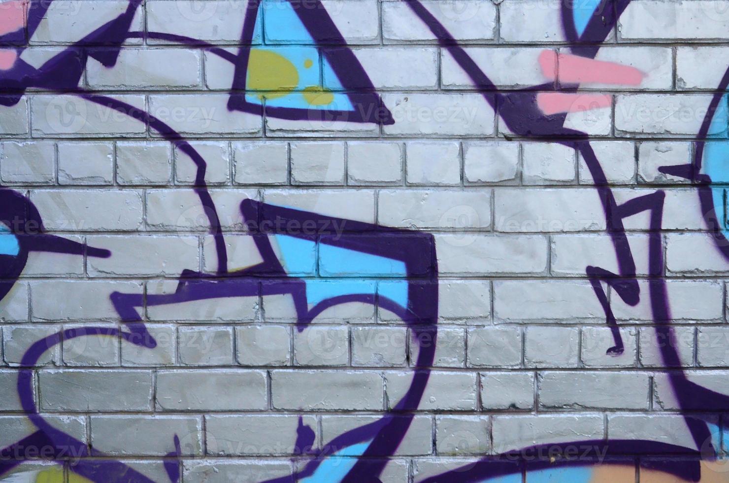 Fragment of graffiti drawings. The old wall decorated with paint stains in the style of street art culture. Colored background texture photo