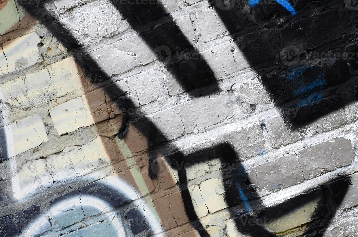 Fragment of graffiti drawings. The old wall decorated with paint stains in the style of street art culture. Colored background texture photo