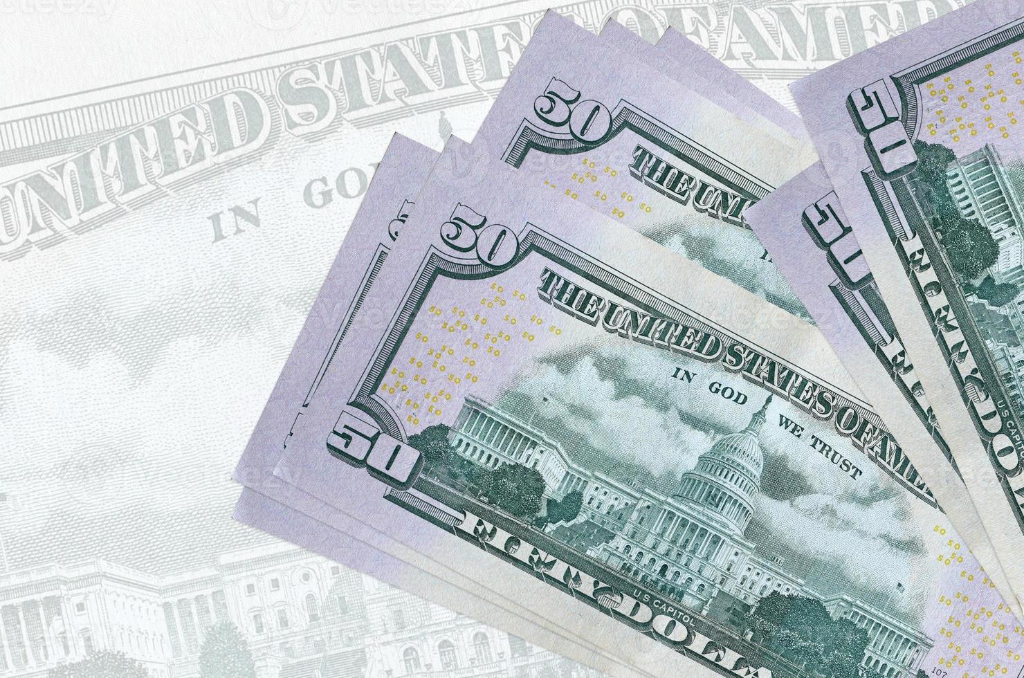 Los billetes de 50 dólares estadounidenses se encuentran apilados en el fondo de un gran billete semitransparente. presentación abstracta de la moneda nacional foto