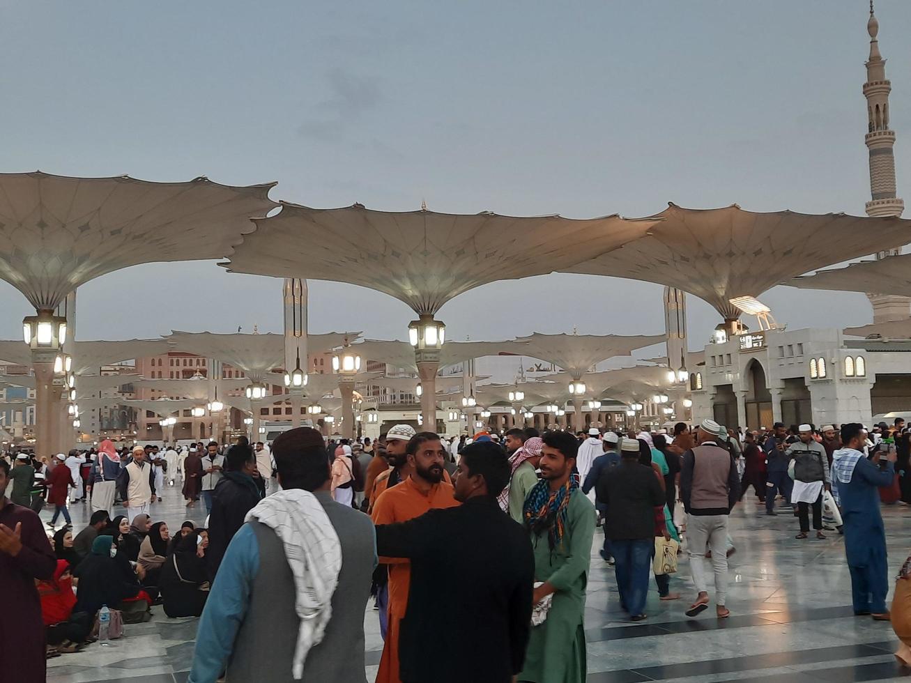 Medina, Saudi Arabia, Dec 2022 - Beautiful evening view in Masjid al-Nabawi, Visitors are seen in the lights of the mosque in the premises of the mosque. photo