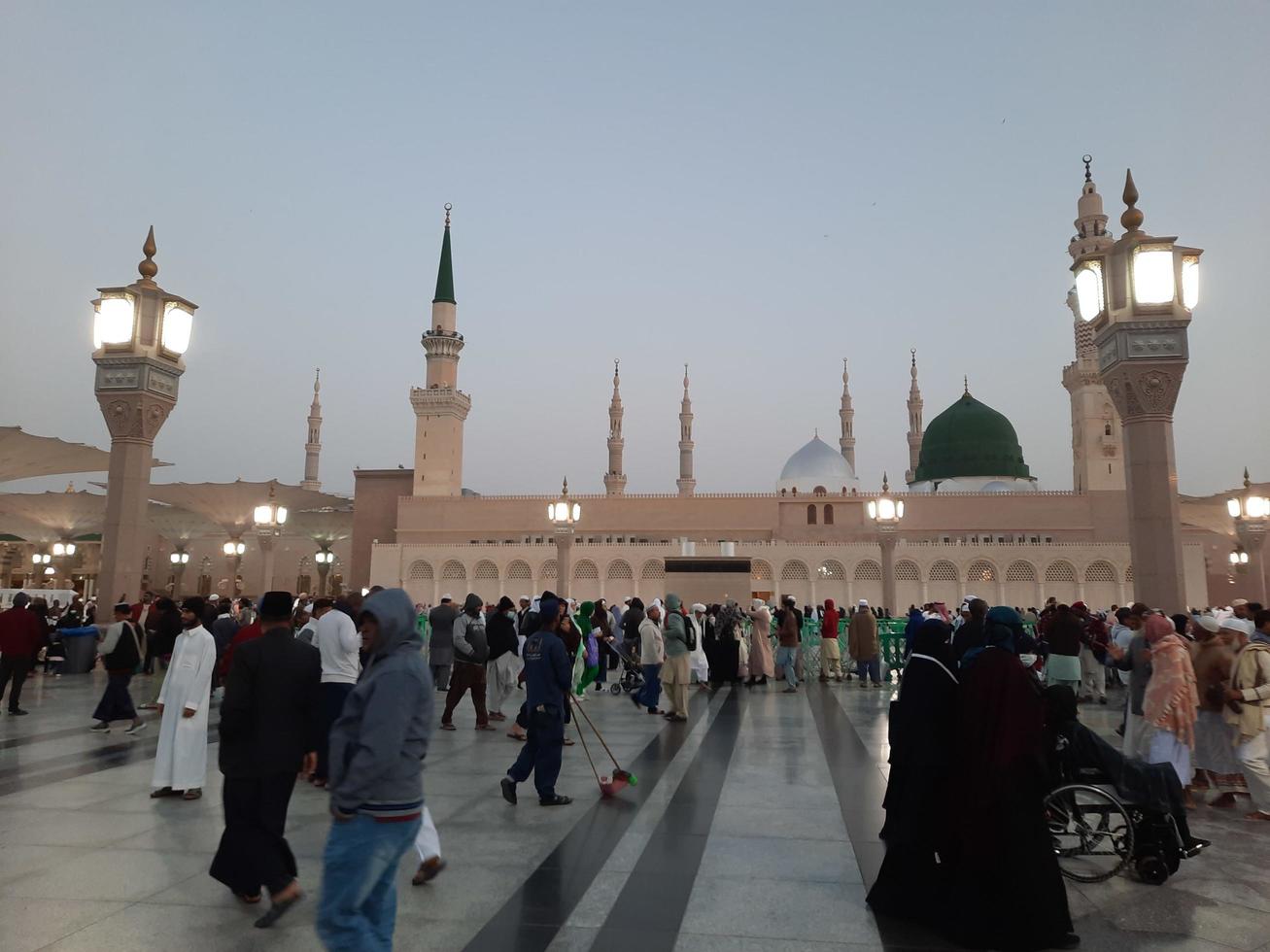 Medina, Saudi Arabia, Dec 2022 - Beautiful evening view in Masjid al-Nabawi, Visitors are seen in the lights of the mosque in the premises of the mosque. photo