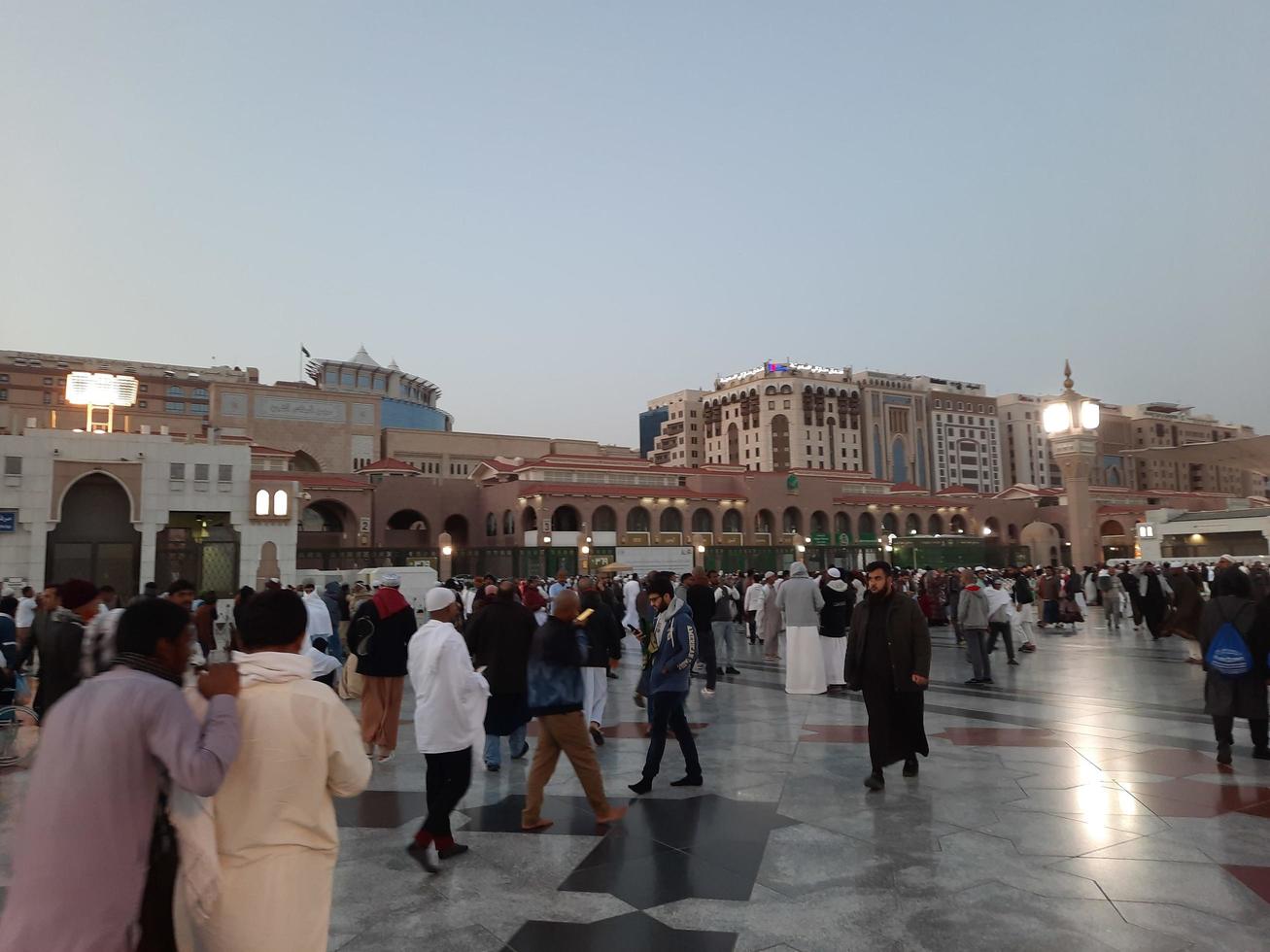 medina, arabia saudita, diciembre de 2022 - hermosa vista nocturna en masjid al-nabawi, los visitantes son vistos en las luces de la mezquita en las instalaciones de la mezquita. foto