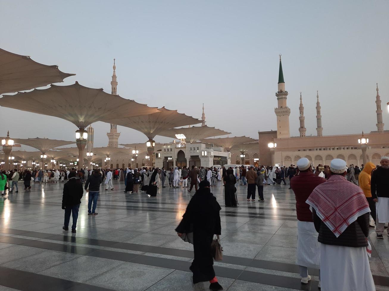 Medina, Saudi Arabia, Dec 2022 - Beautiful evening view in Masjid al-Nabawi, Visitors are seen in the lights of the mosque in the premises of the mosque. photo