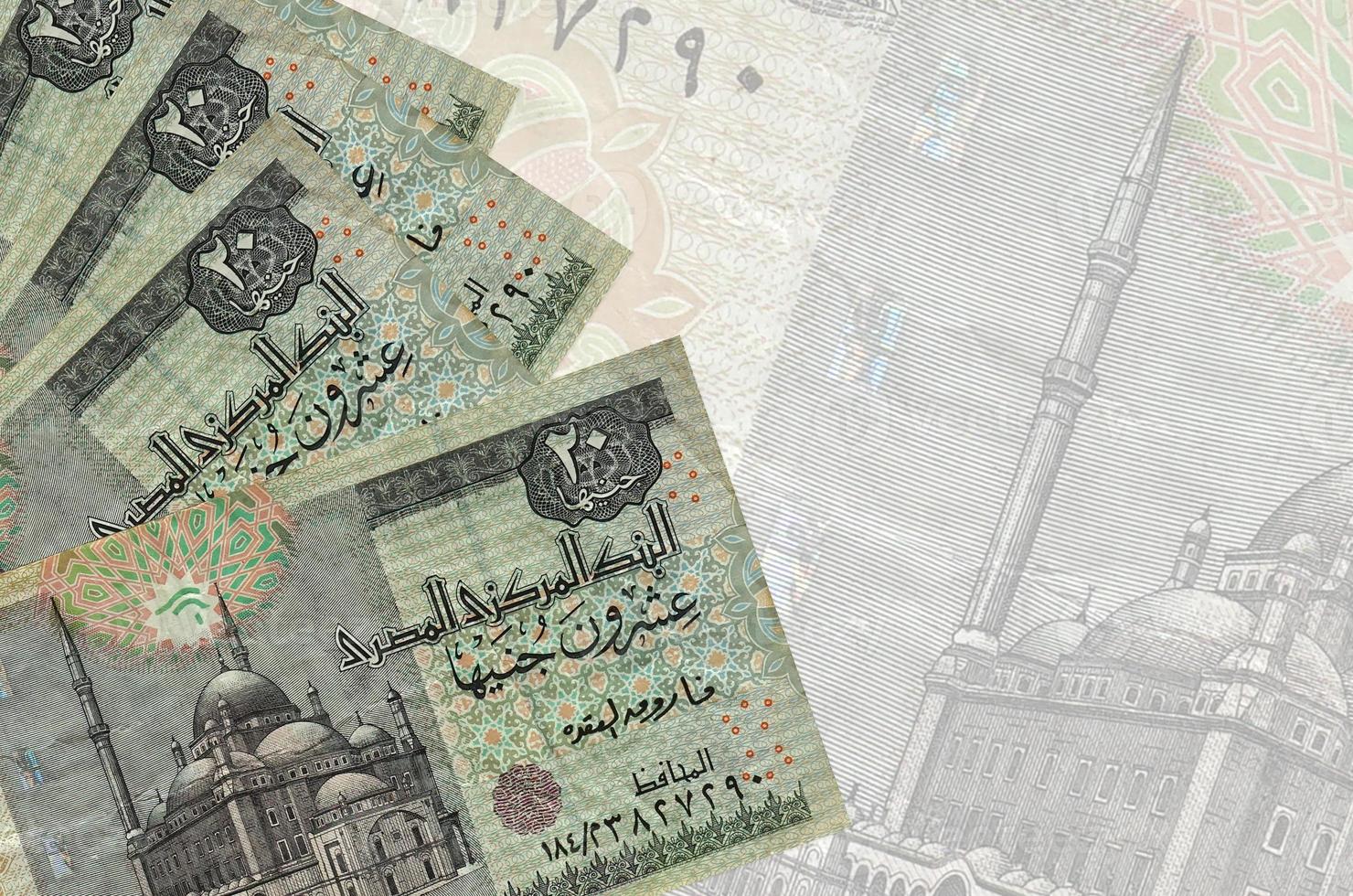 20 Egyptian pounds bills lies in stack on background of big semi-transparent banknote. Abstract business background photo