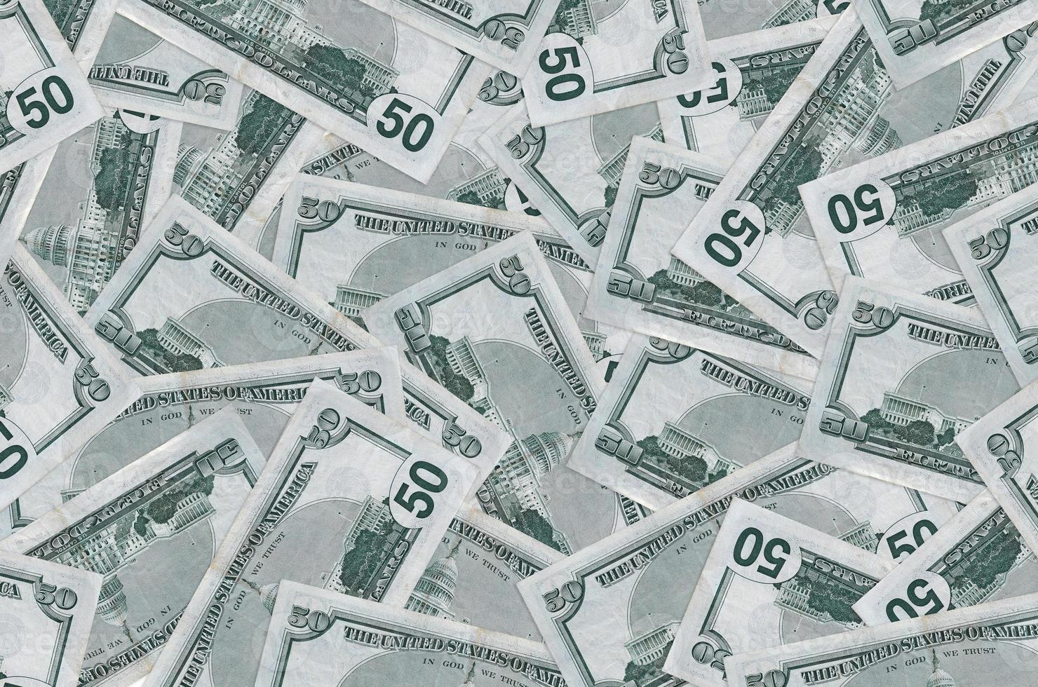 50 US dollars bills lies in big pile. Rich life conceptual background photo