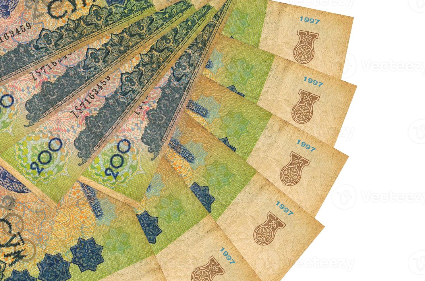 200 billetes de som uzbekistani se encuentran aislados en fondo blanco con espacio de copia apilado en forma de abanico de cerca foto