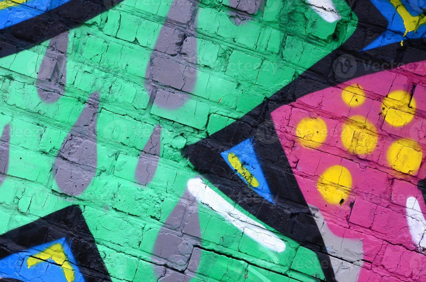 Fragment of graffiti drawings. The old wall decorated with paint stains in the style of street art culture. Colored background texture photo