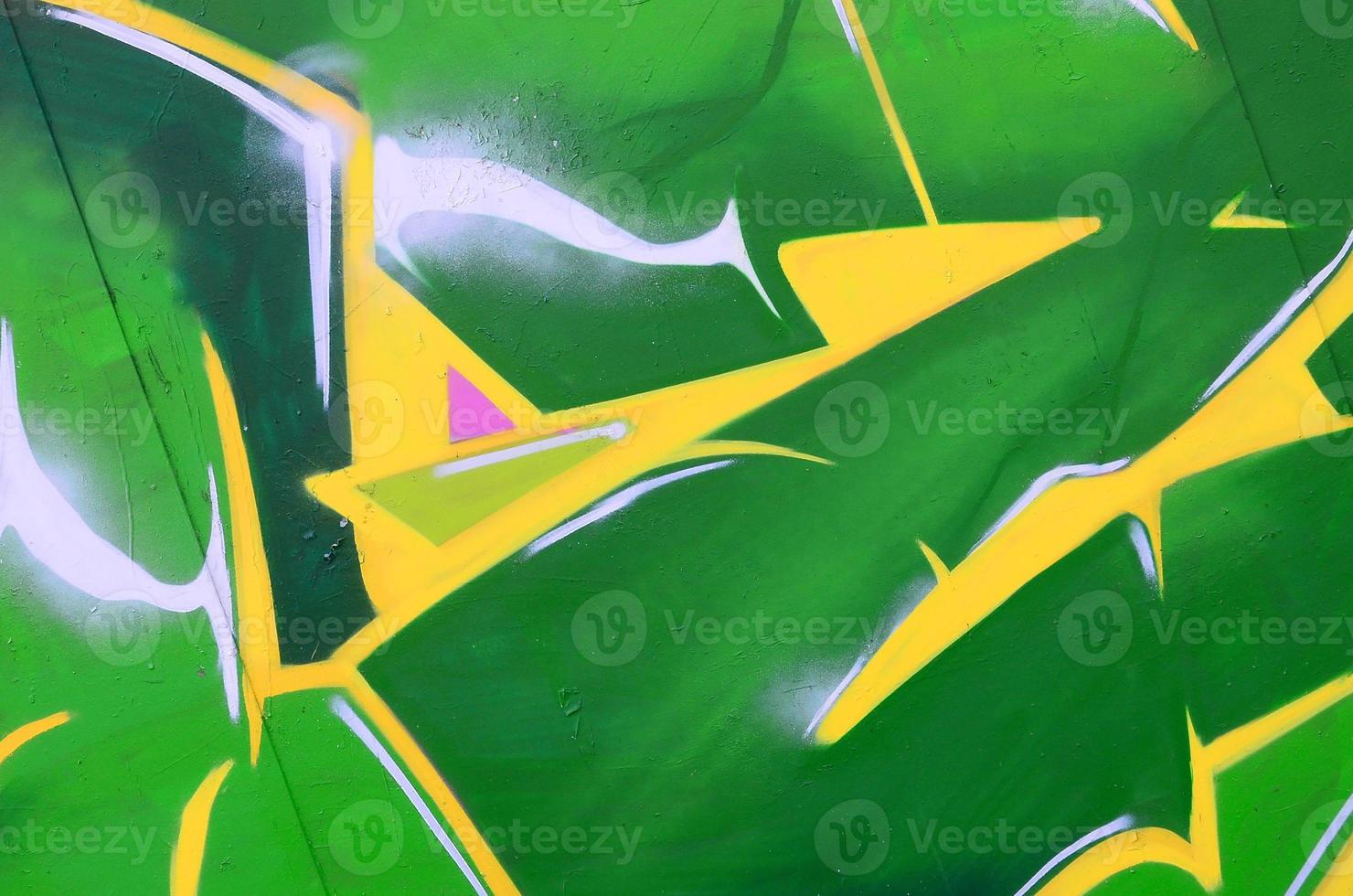 Fragment of graffiti drawings. The old wall decorated with paint stains in the style of street art culture. Colored background texture photo