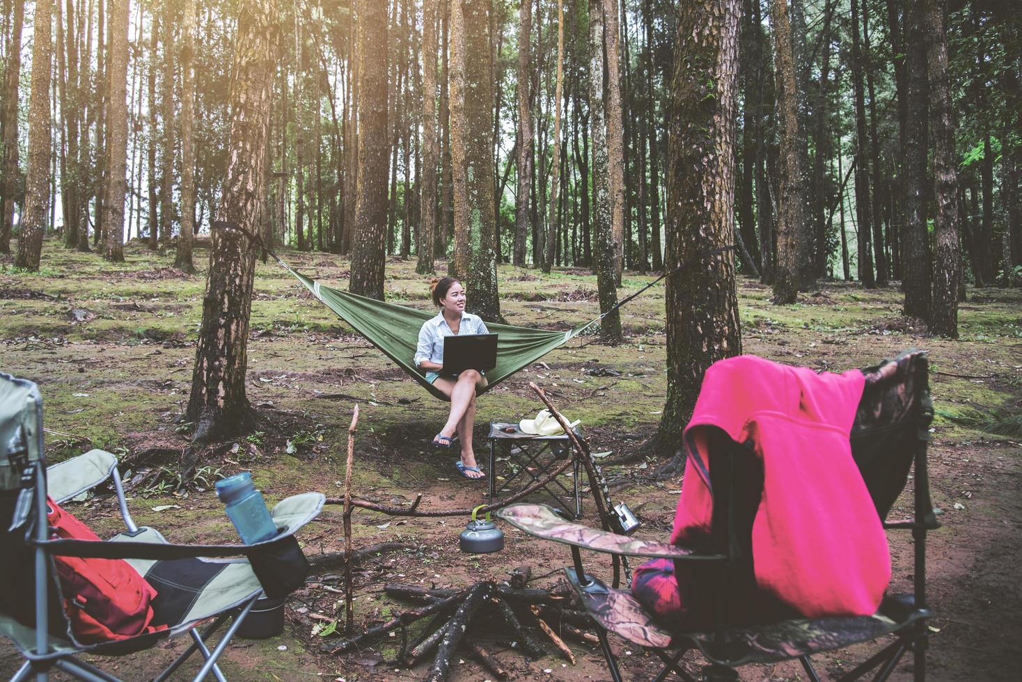 Las mujeres asiáticas viajan relajadas de forma natural. sentado trabajando usando un cuaderno. en la hamaca. camping en el parque nacional doi inthanon en chiangmai. En Tailandia foto