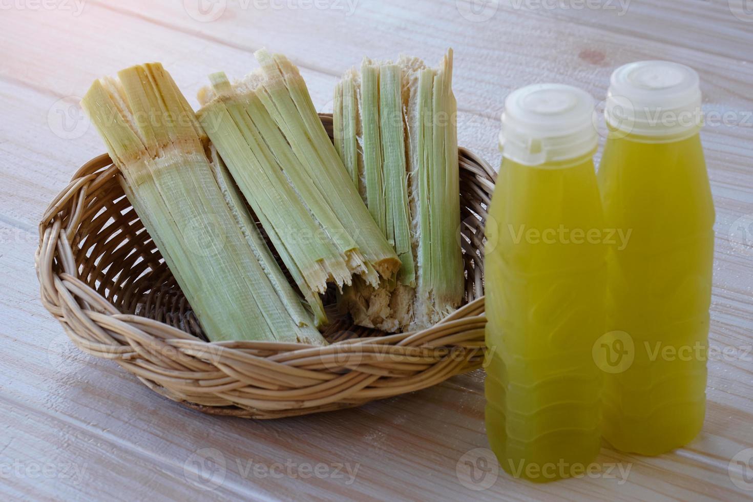 Bottles of fresh sugar cane juice.  and bagasse after squeezing for a drink in basket. Concept, healthy natural beverage made from agriculture crop. Homemade drinks, has medicinal , herbal properties photo