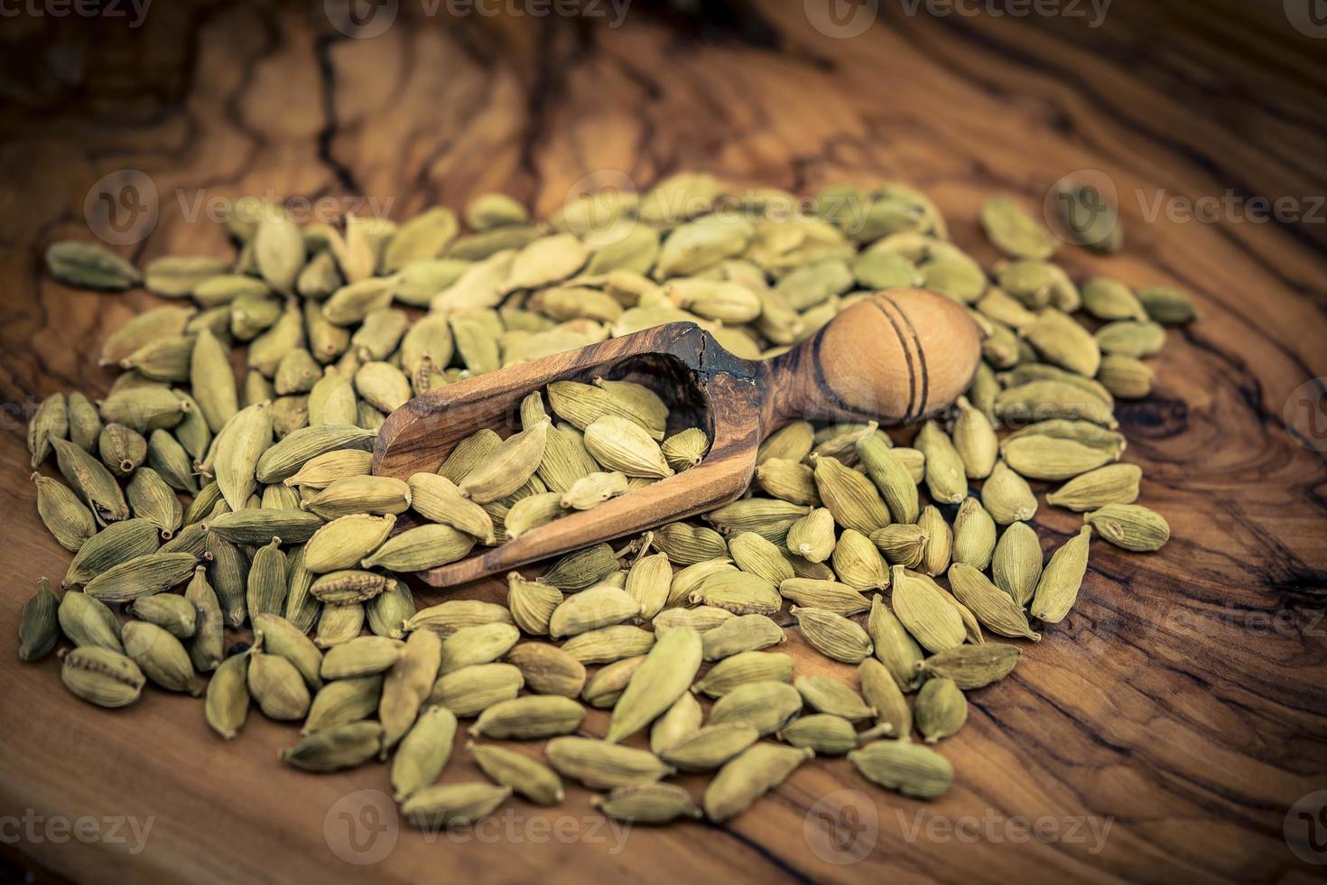 green cardamom Elettaria cardamomum on olive wood photo