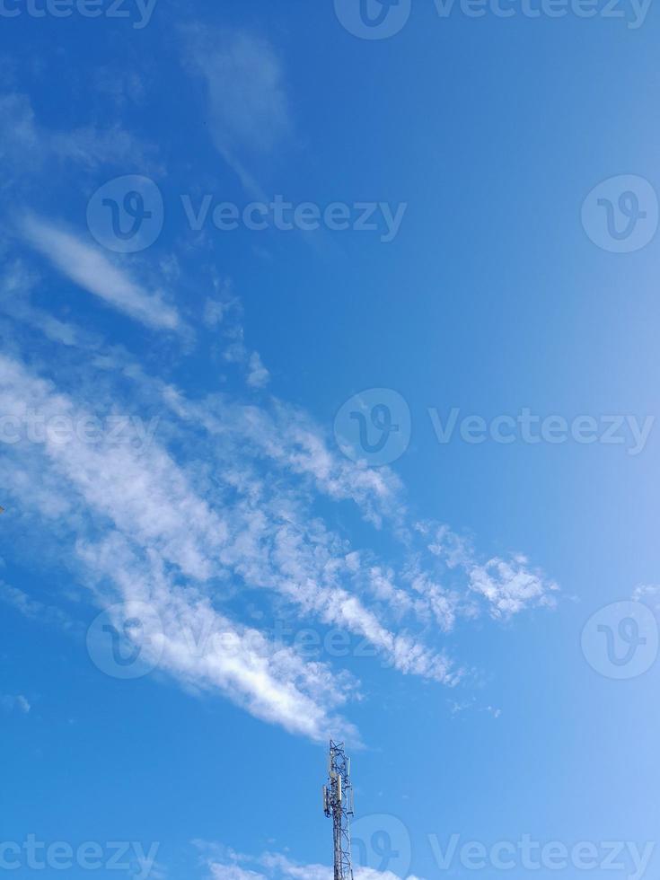 transmitter tower with a background of blue sky and clouds photo