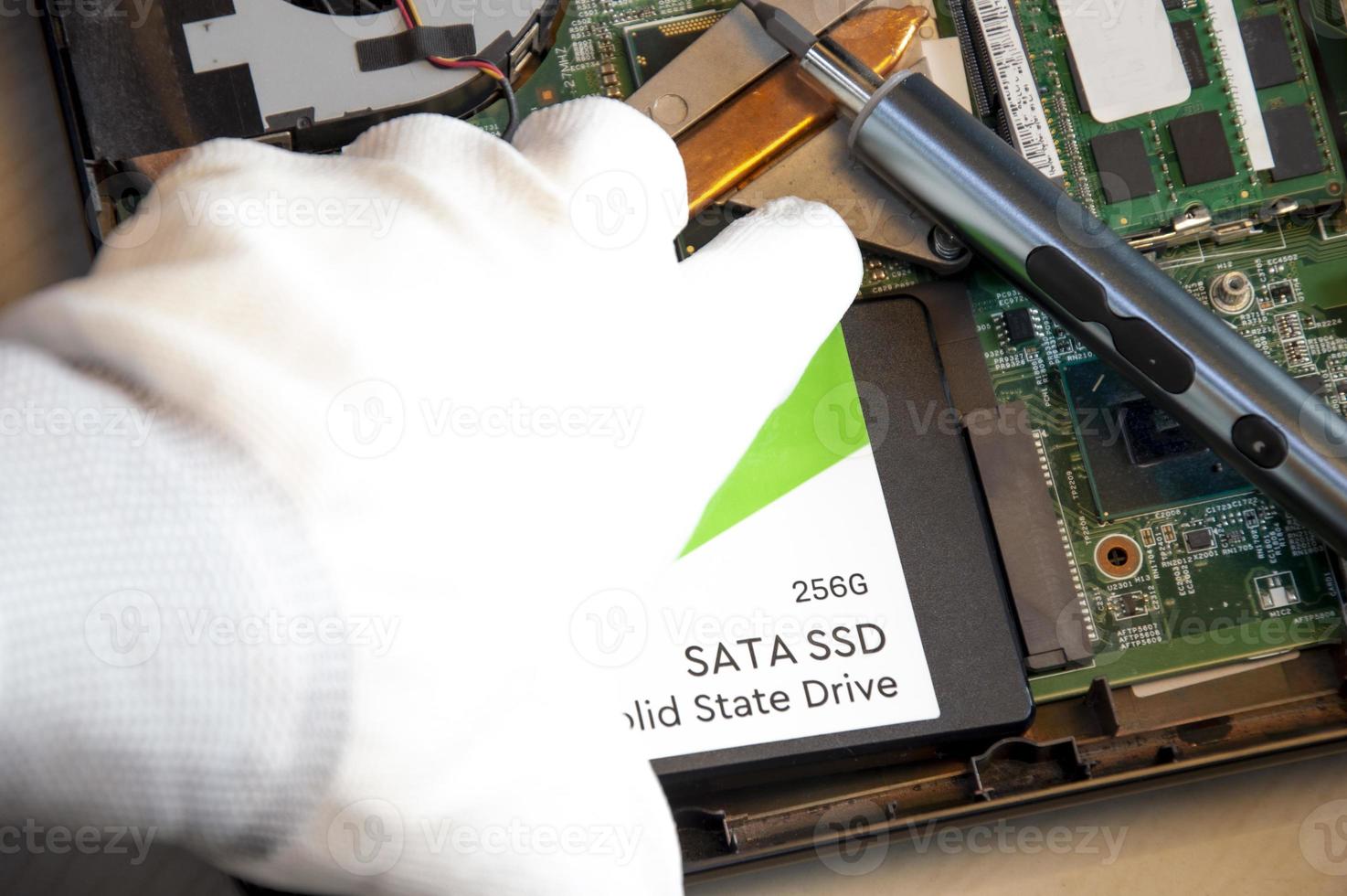 Technician installing ssd drive in old computer, upgrading computer photo