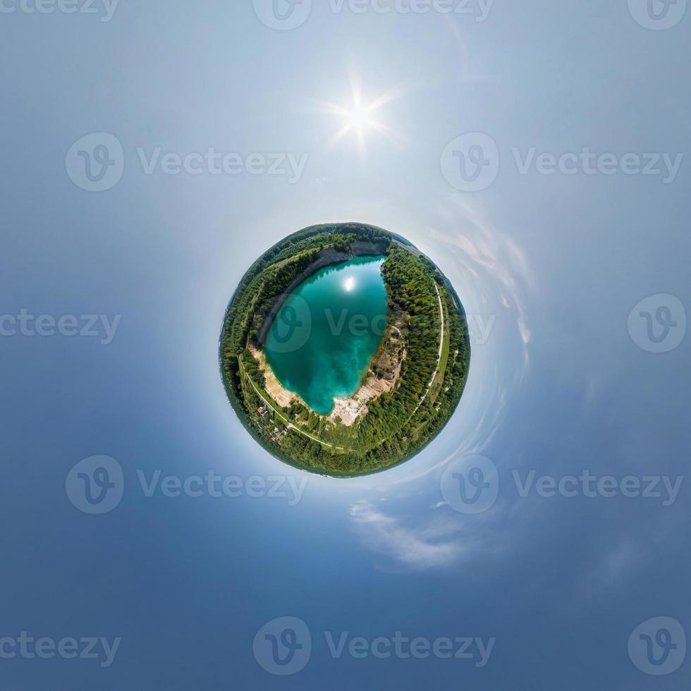 green tiny planet in blue sky with beautiful clouds. Transformation of spherical panorama 360 degrees. Spherical abstract aerial view. Curvature of space. photo