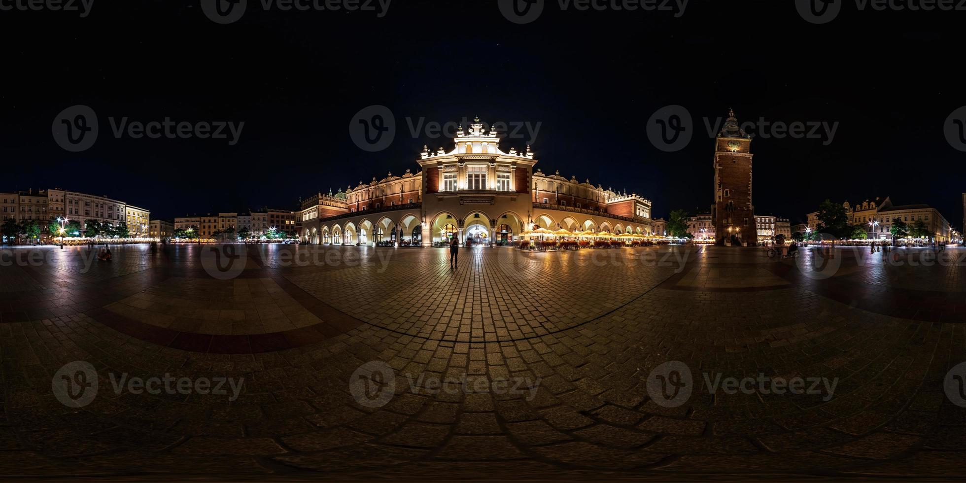 night full 360 panorama on main market square in center of old town with historical buildings, temples and town hall with a lot of tourists in equirectangular projection photo