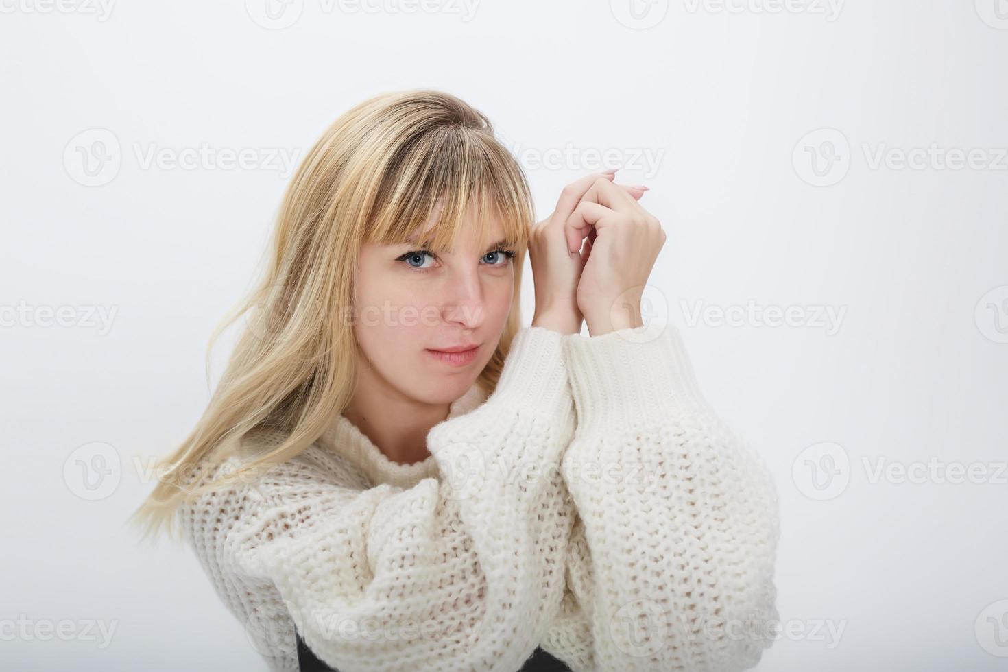 close up portrait of blonde girl model in white wool sweater on white background in studio photo