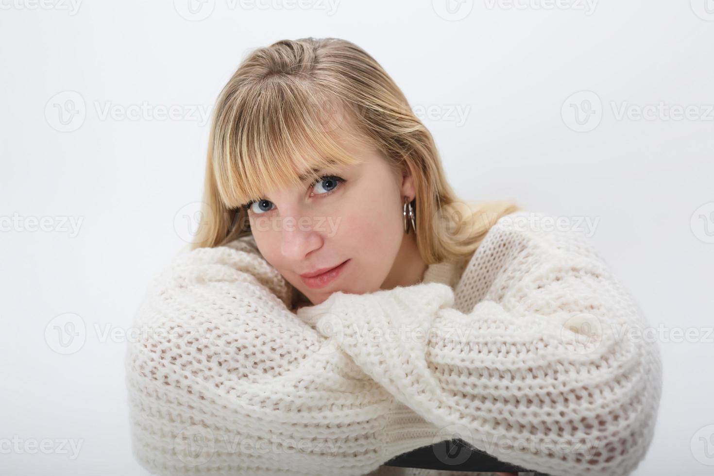 close up portrait of blonde girl model in white wool sweater on white background in studio photo