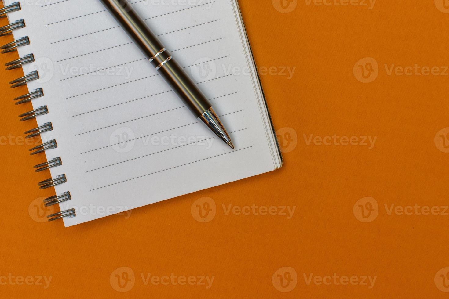 un cuaderno con una página en blanco y un bolígrafo sobre él foto