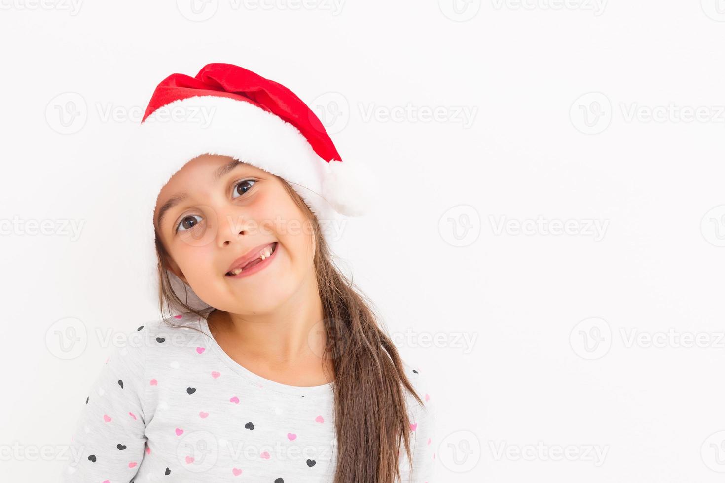 linda niña en el sombrero de santa claus sobre un fondo blanco foto