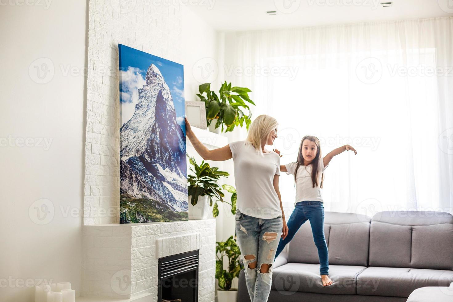 woman hangs photo canvas on wall