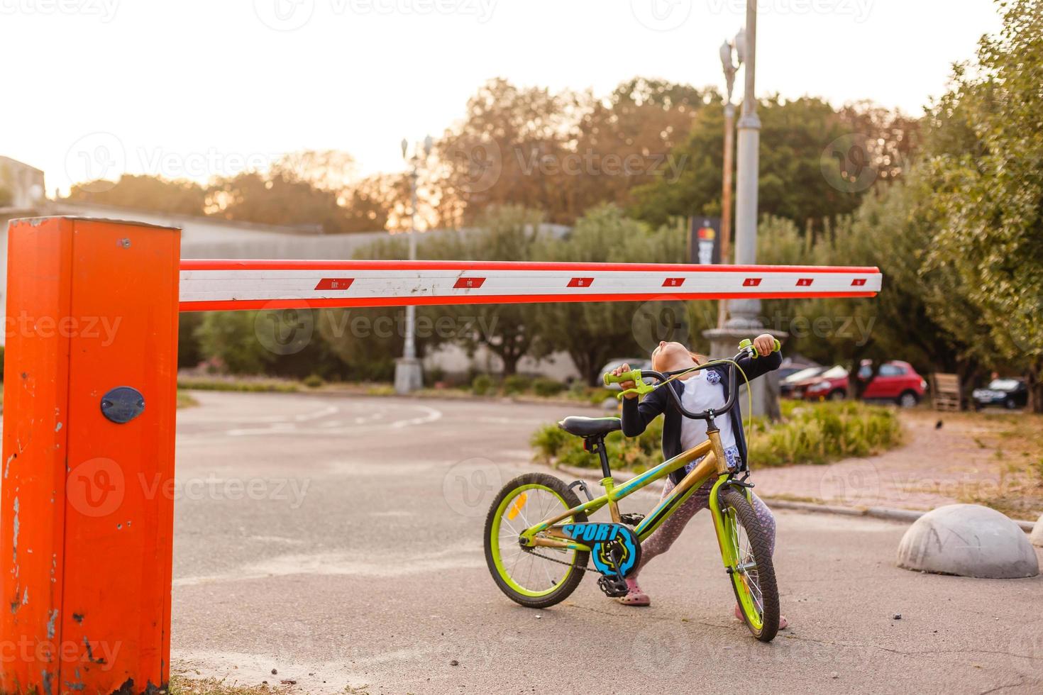 little girl on a bicycle bike near the barrier photo